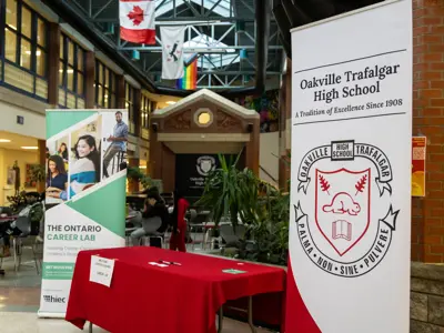 Banner for “The Ontario Career Lab” in a school lobby beside a red check-in table labeled “Welcome Career Coaches – Check-In.