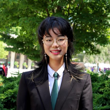 headshot of Heidi Huang who is standing in front of a tree outside.