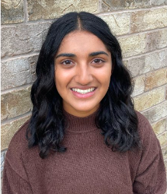 headshot of Diya Kalia who is standing in front of a brick wall.
