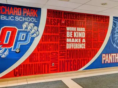 A colorful school wall mural for Orchard Park Public School featuring the "OP" panther claw logo, a red word cloud of school values like "Responsibility" and "Integrity," the motto "Work hard, be kind, make a difference," and a panther head graphic with the word "Panthers."